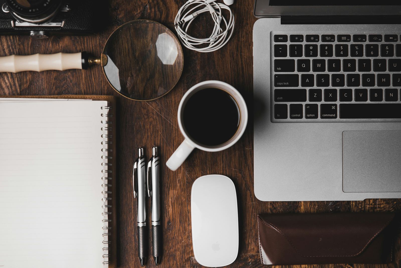 Escritorio de trabajo con laptop, cámara y artículos de oficina